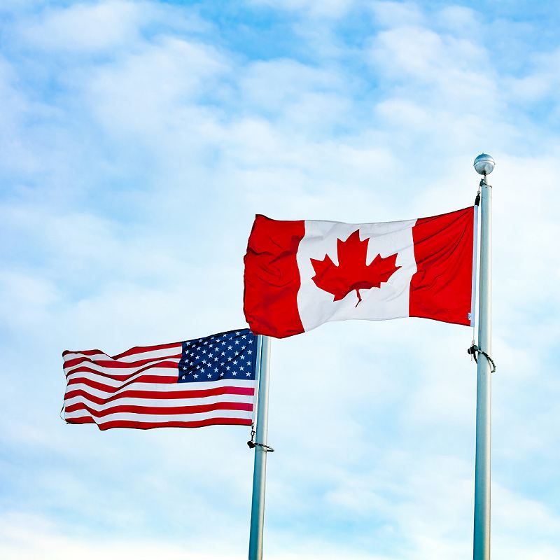 U.S. And Canadian Flags Flying Side By Side