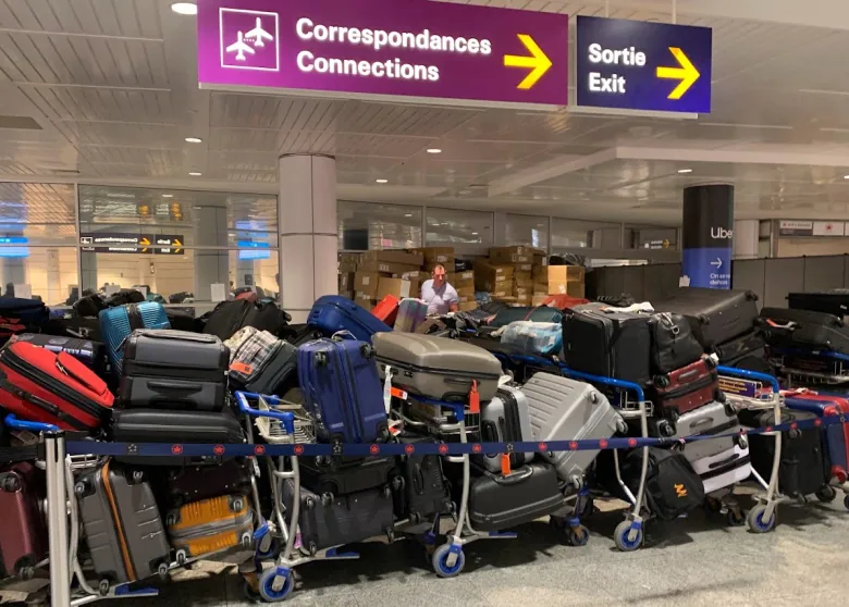Dozens of suitcases and other luggage sit stacked up in Montreal airport.